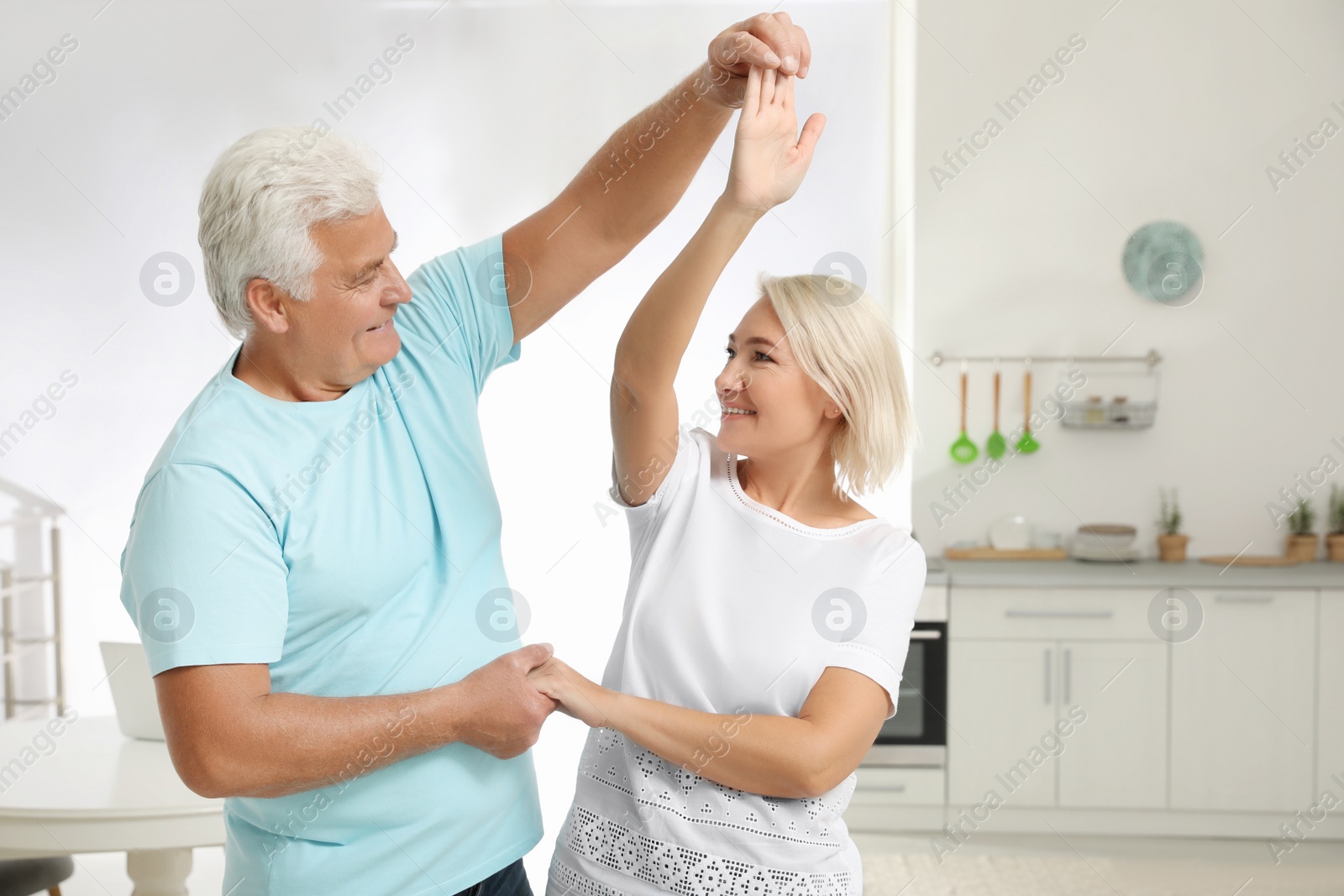 Photo of Happy mature couple dancing together in kitchen