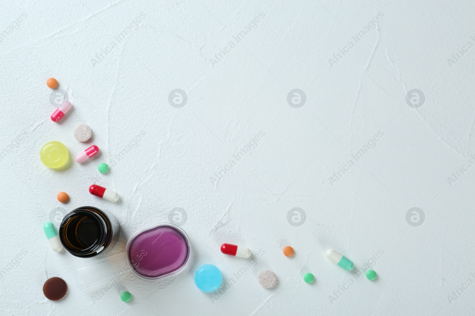 Photo of Flat lay composition with cough drops, syrup and pills on white background. Space for text