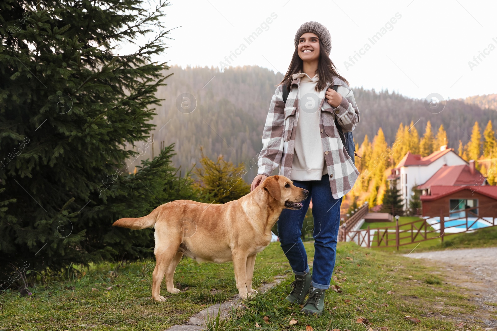 Photo of Happy woman and adorable dog in mountains. Traveling with pet