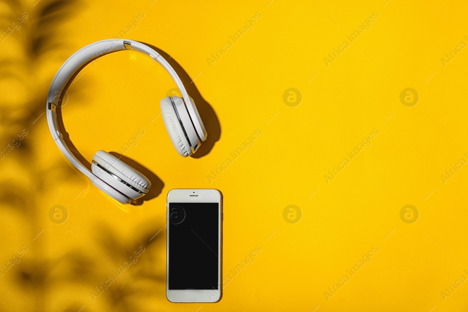 Photo of Flat lay composition with smartphone, headphones and space for text on color background