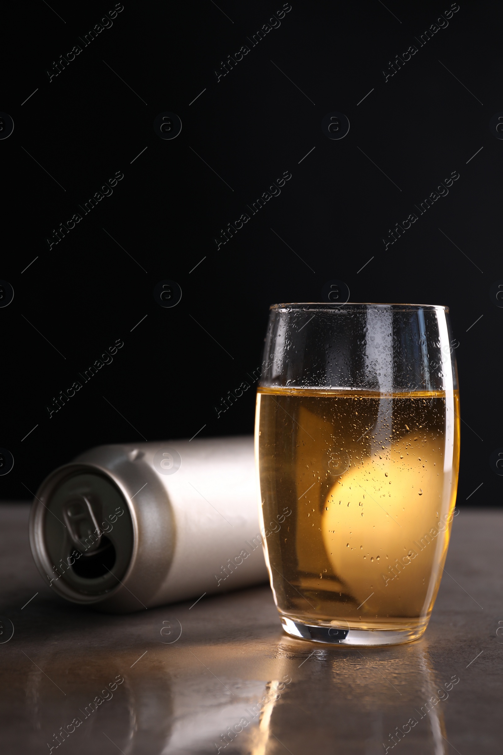 Photo of Energy drink in glass and aluminium can on grey table