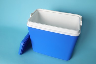 Photo of Open blue plastic cool box on turquoise background