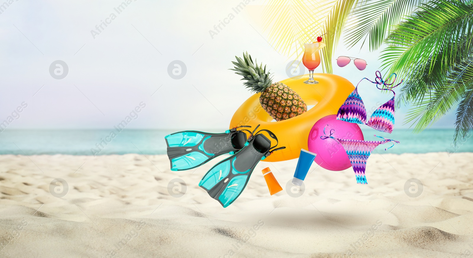 Image of Pineapple, cocktail and beach accessories flying over sandy beach. Banner design with space for text