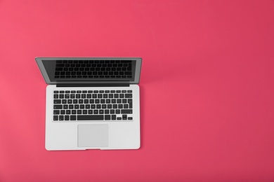 Photo of Modern laptop on pink background, top view. Space for text