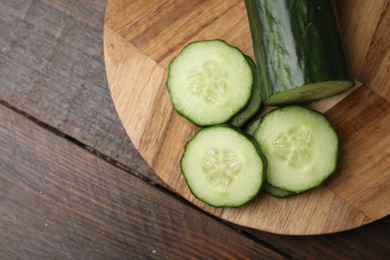 Fresh cut cucumber on wooden table, top view. Space for text