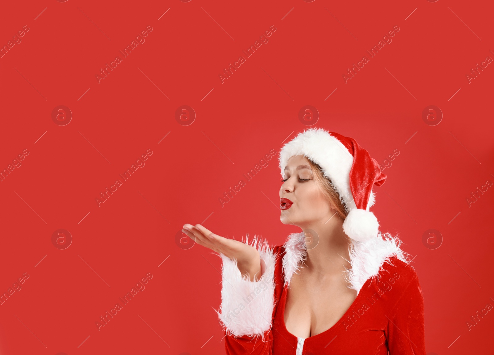 Photo of Beautiful Santa girl on red background. Christmas eve