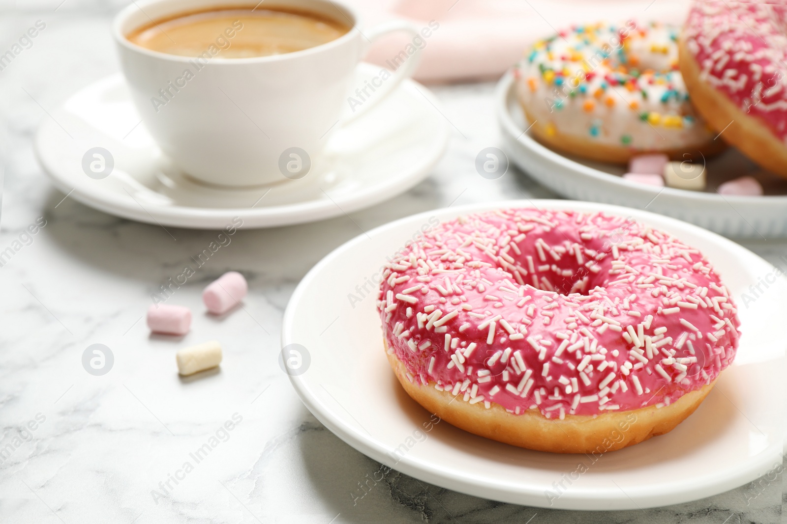 Photo of Yummy donut with sprinkles and coffee on white marble table