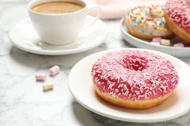 Photo of Yummy donut with sprinkles and coffee on white marble table