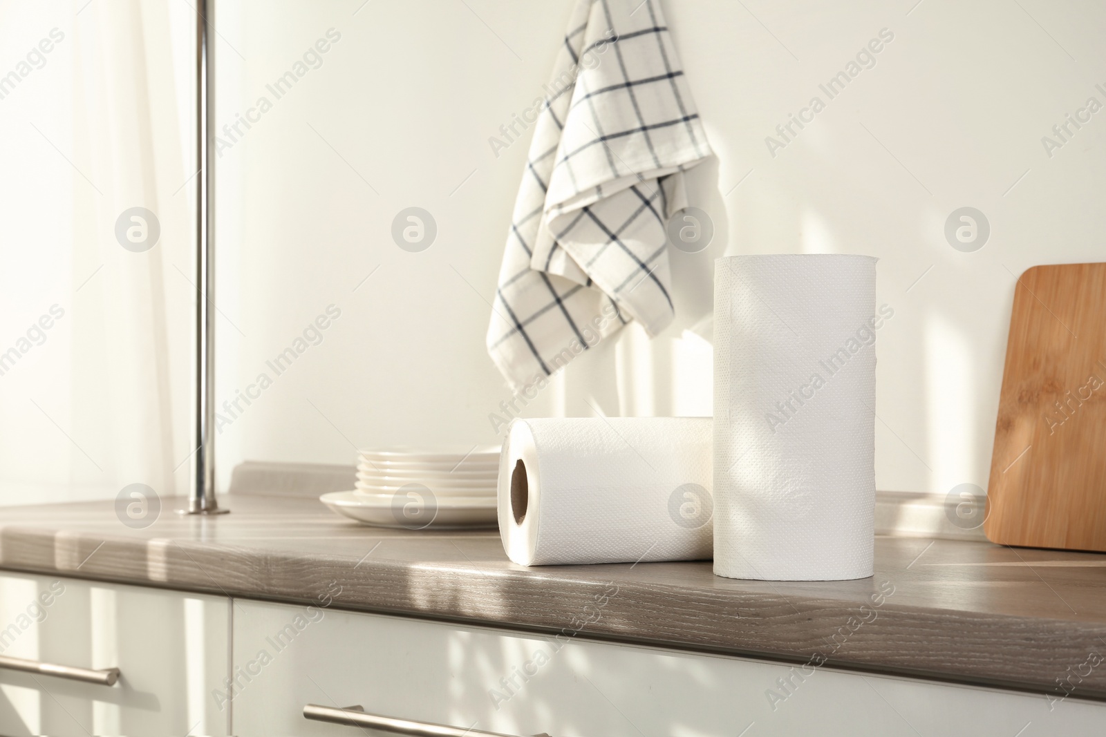 Photo of Rolls of paper towels on wooden table in kitchen