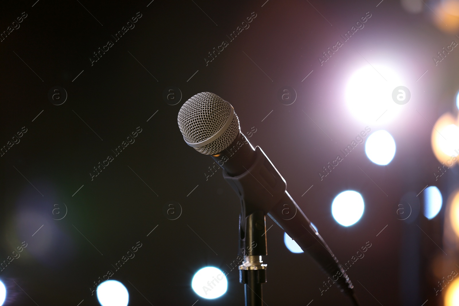 Photo of Microphone against festive lights, space for text. Musical equipment