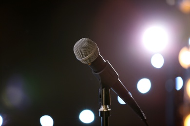 Microphone against festive lights, space for text. Musical equipment