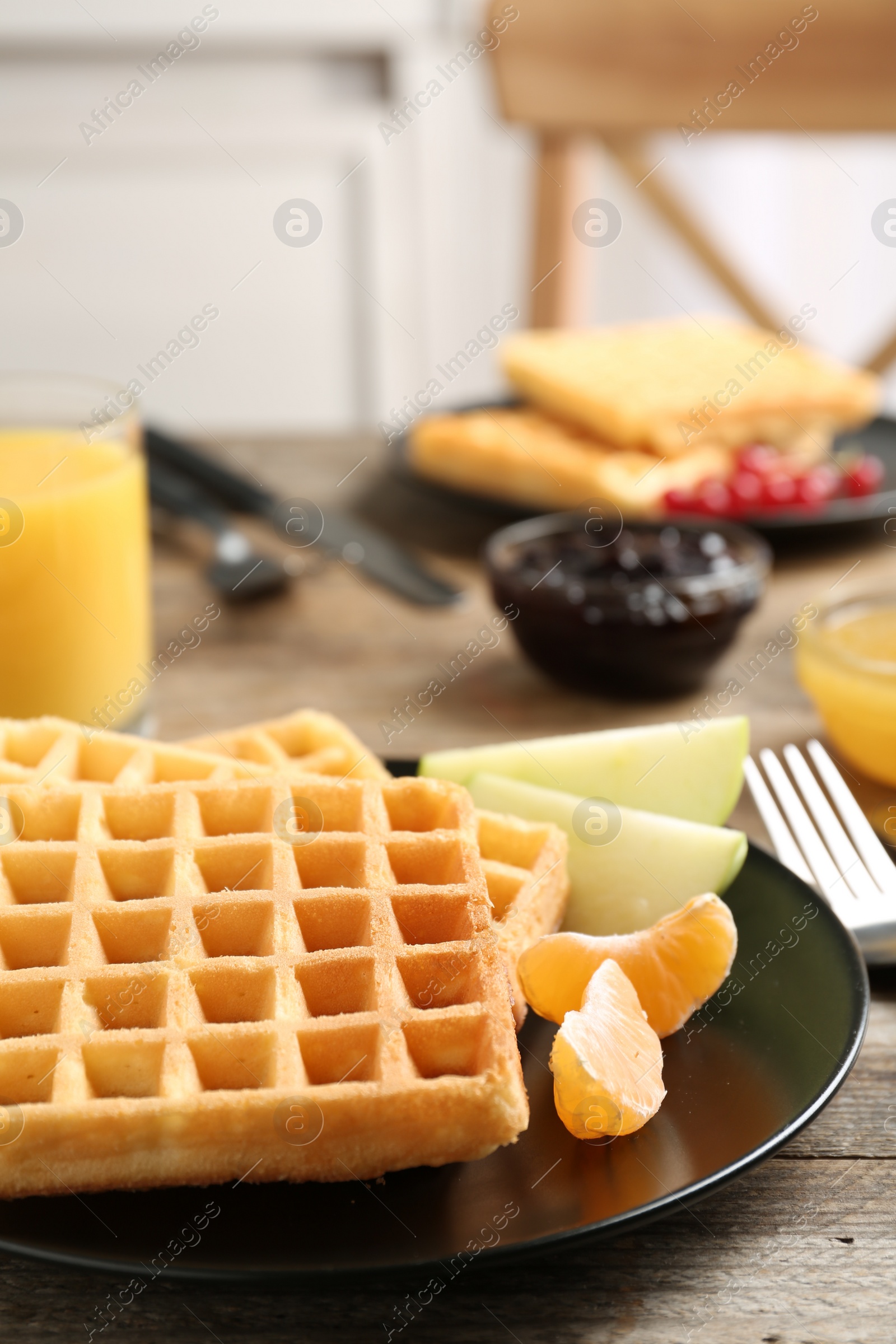 Photo of Waffles with fruits served on wooden table. Delicious breakfast