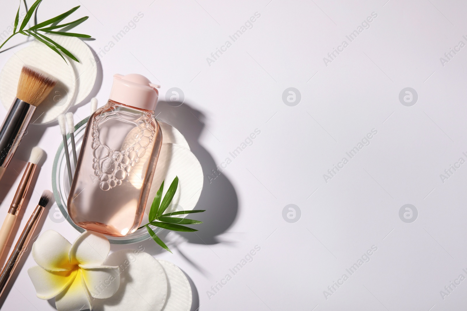 Photo of Flat lay composition with micellar water on white background. Space for text