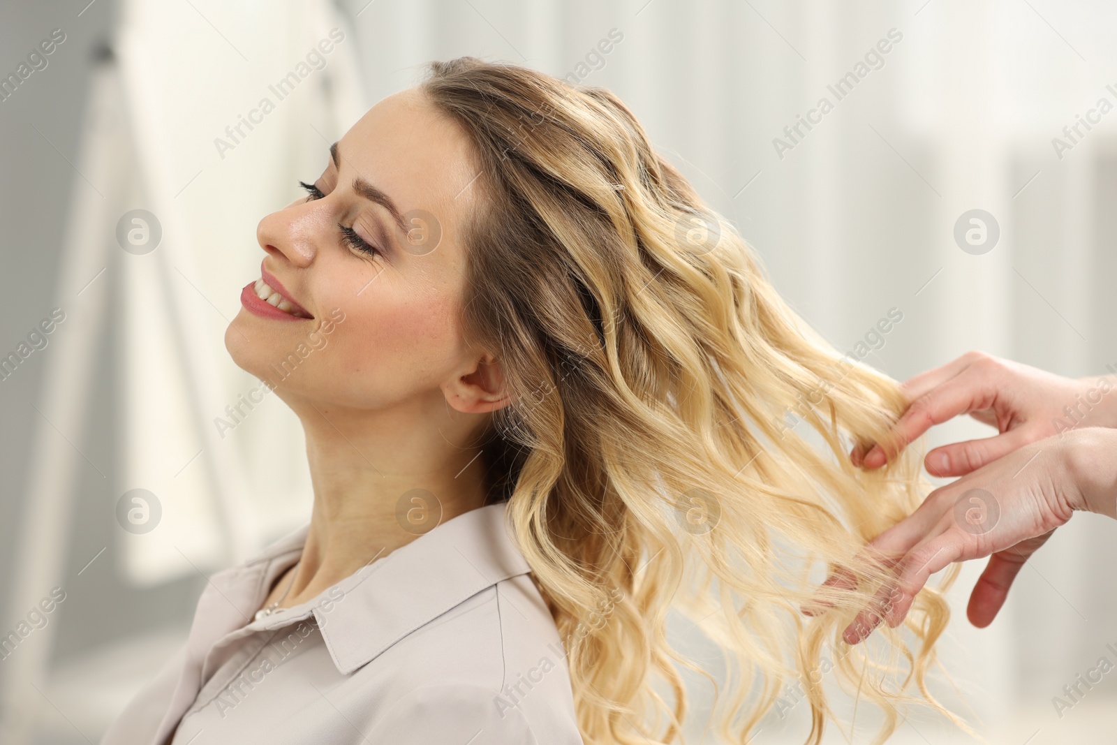 Photo of Hair styling. Professional hairdresser working with smiling client indoors, closeup