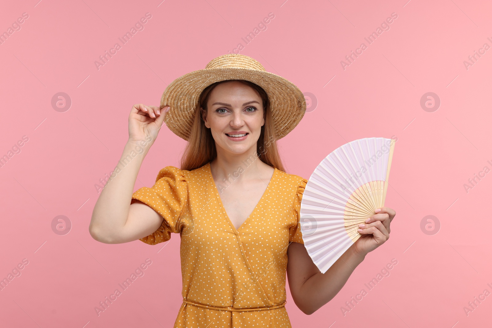 Photo of Happy woman with hand fan on pink background