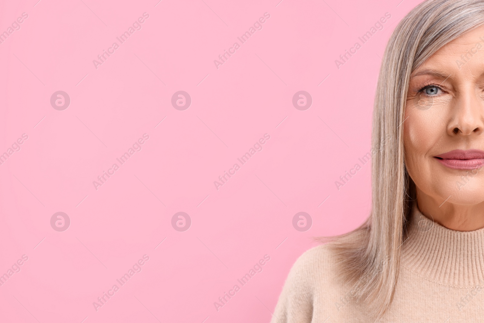 Photo of Portrait of beautiful middle aged woman on pink background, closeup. Space for text