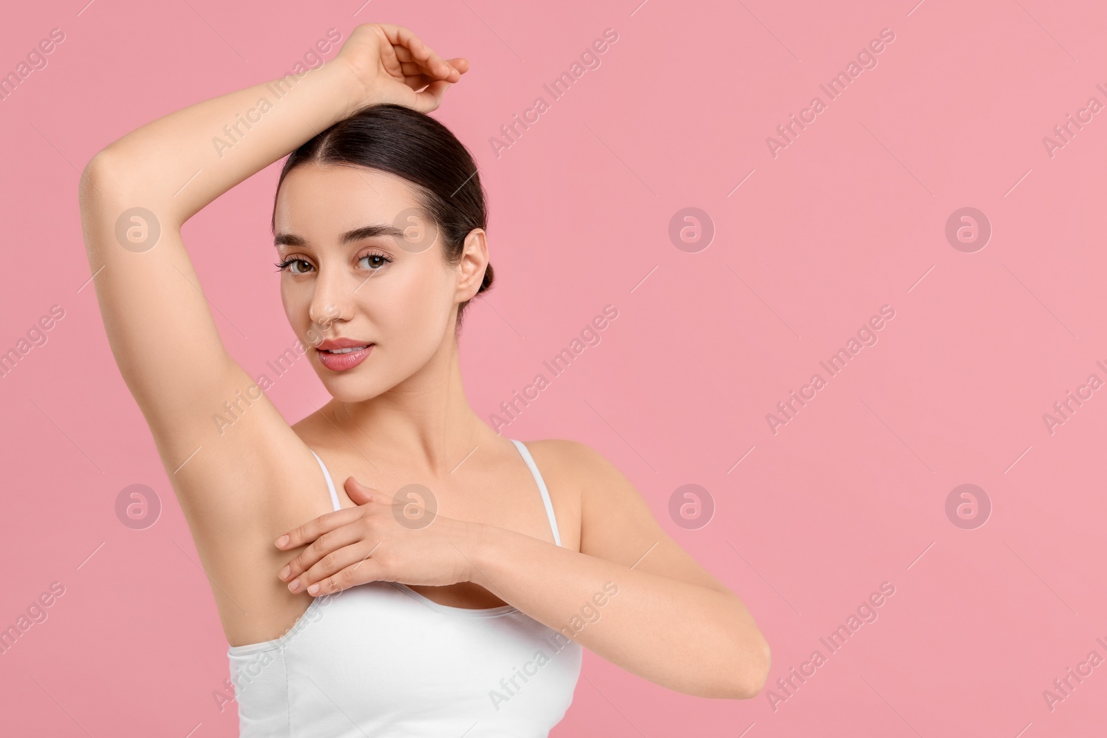 Photo of Beautiful woman showing armpit with smooth clean skin on pink background, space for text