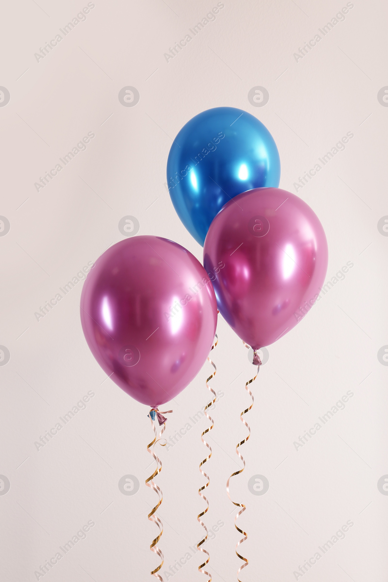 Photo of Color balloons with ribbons on white background