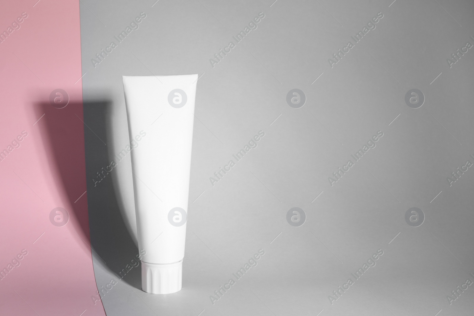 Photo of Blank tube of toothpaste on color background. Space for text