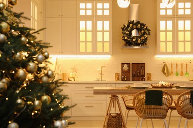 Photo of Beautiful Christmas tree in spacious kitchen, closeup. Space for text