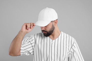 Man in stylish white baseball cap on light grey background