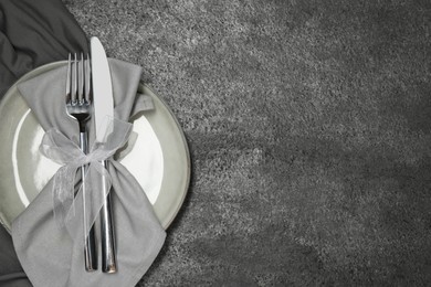 Photo of Stylish setting with elegant cutlery on grey table, top view. Space for text