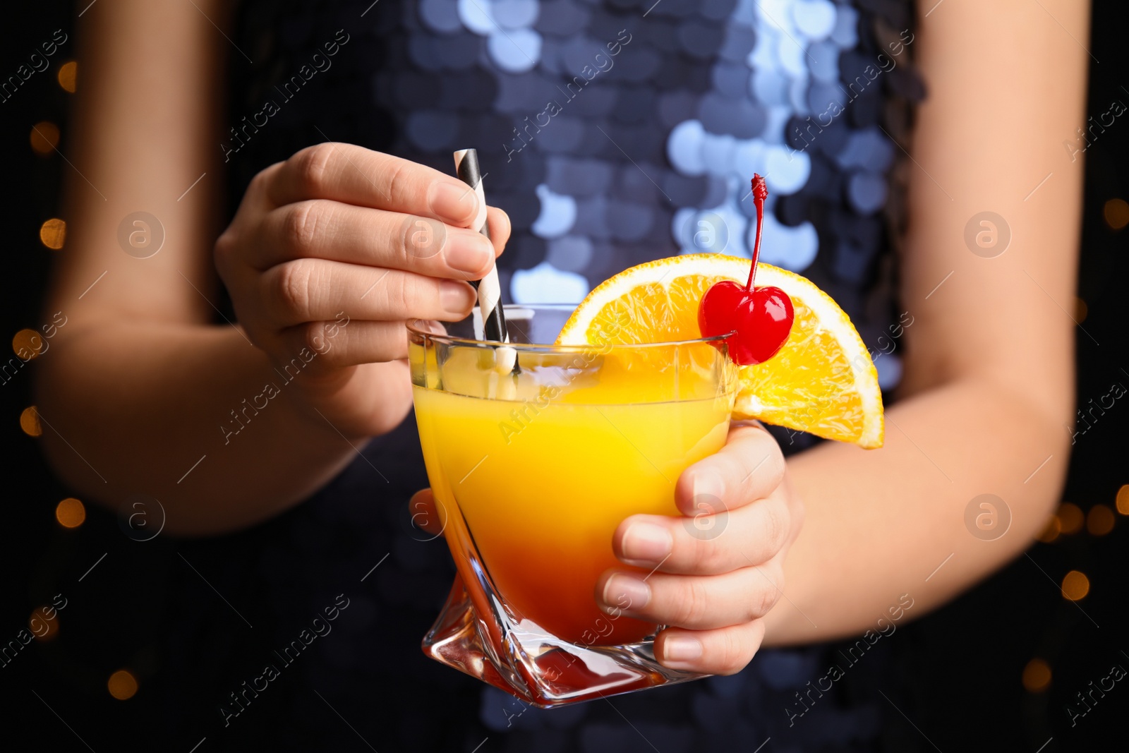 Photo of Woman with glass of Tequila Sunrise, closeup. Delicious alcoholic cocktail