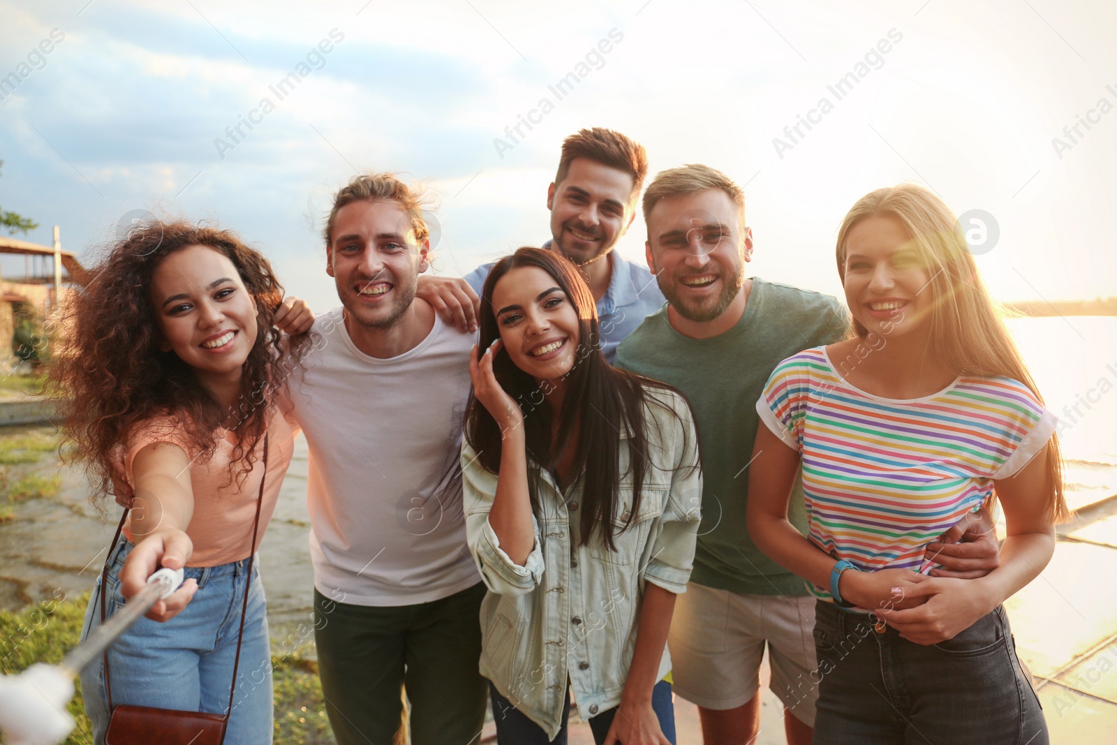 Photo of Happy young people taking selfie outdoors on sunny day