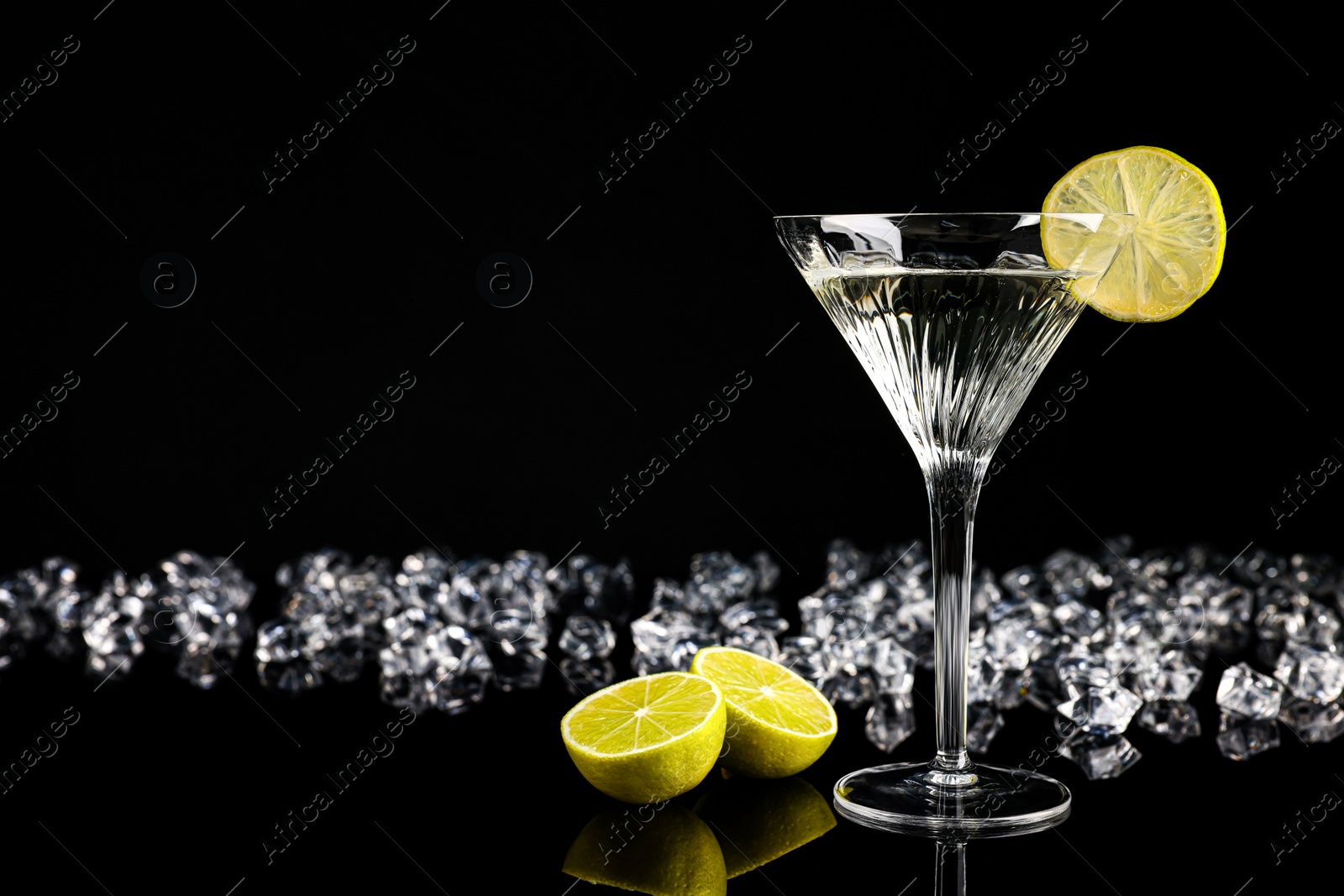 Photo of Martini cocktail and ice cubes on black background, space for text