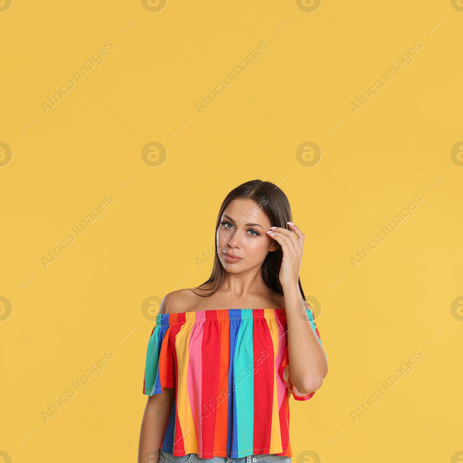 Photo of Portrait of beautiful young woman on yellow background