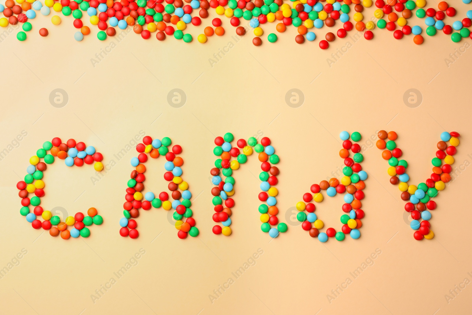 Photo of Word Candy made of tasty sweets on beige background, flat lay