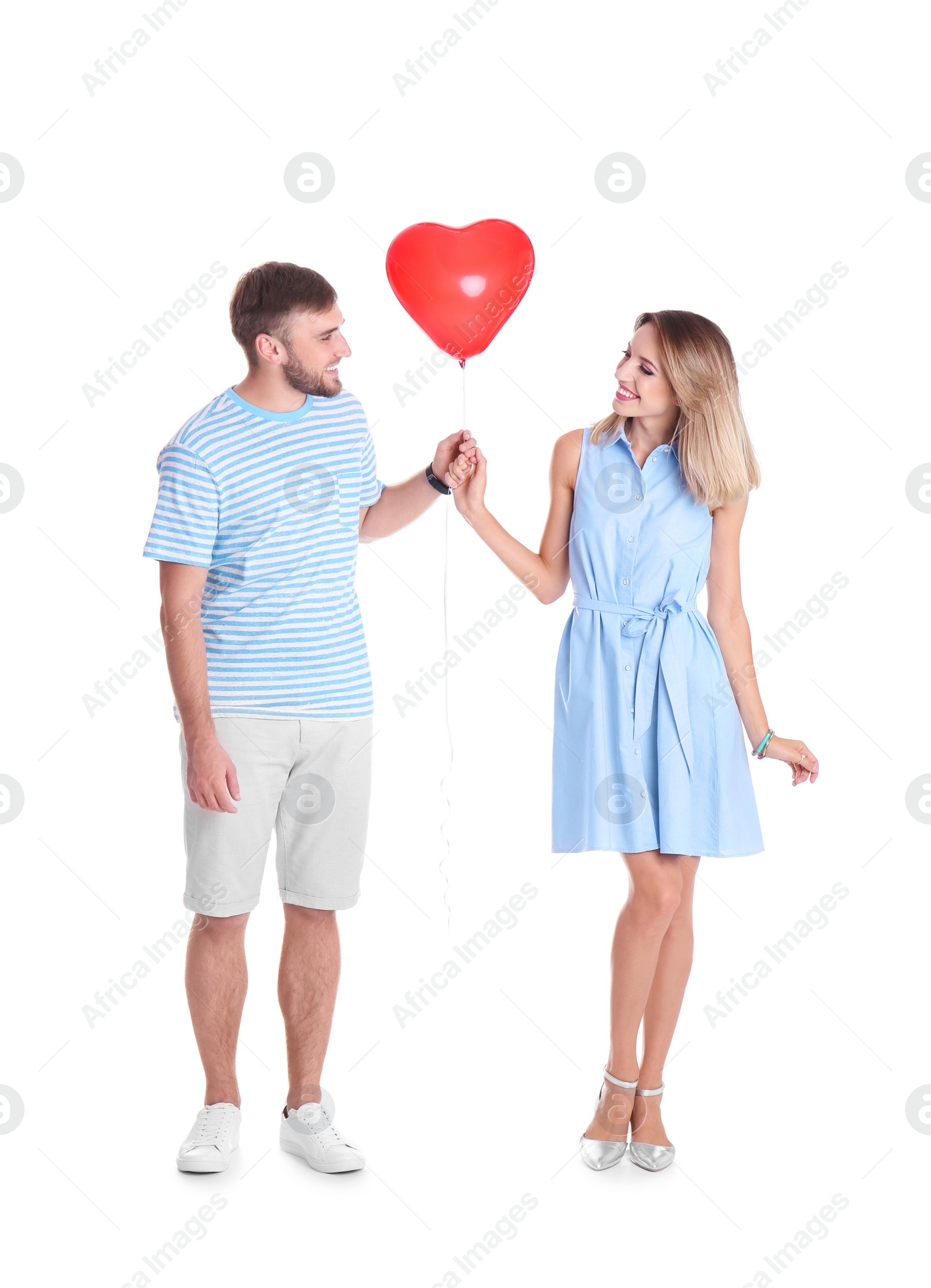 Photo of Young couple with heart-shaped air balloon on white background. Celebration of Saint Valentine's Day