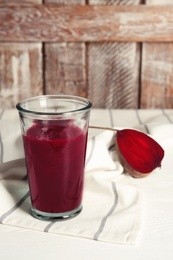 Photo of Glass of tasty beet smoothie on table