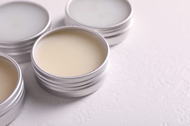 Photo of Different lip balms on white table, closeup. Space for text