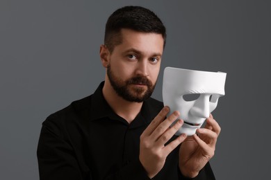 Photo of Multiple personality concept. Man with mask on grey background