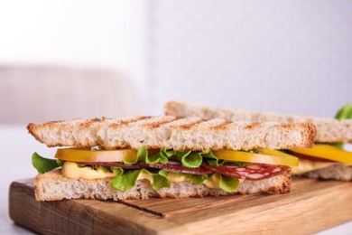 Wooden board with tasty sandwiches, closeup. Space for text