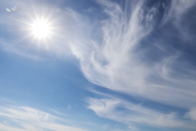 Photo of Bright sun and fluffy white clouds in blue sky