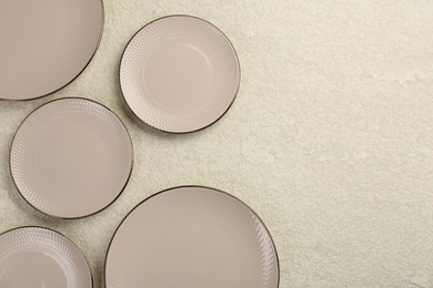 Photo of Beautiful ceramic plates on beige table, flat lay. Space for text