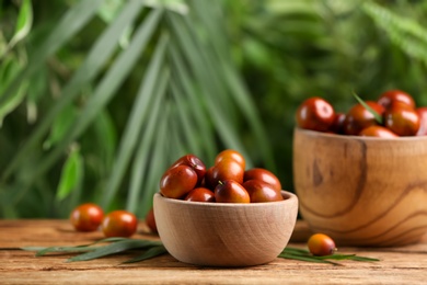 Photo of Fresh ripe oil palm fruits on wooden table