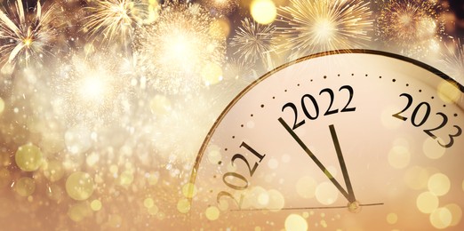 Image of Clock counting last moments to New 2022 Year and beautiful fireworks on background, banner design