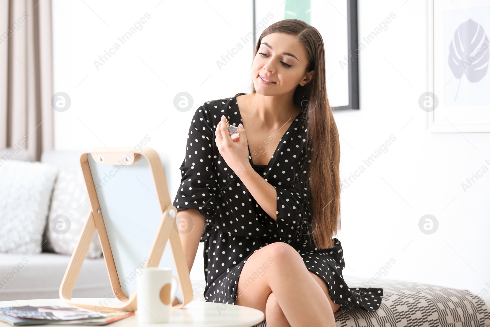 Photo of Young beautiful woman looking in mirror at home