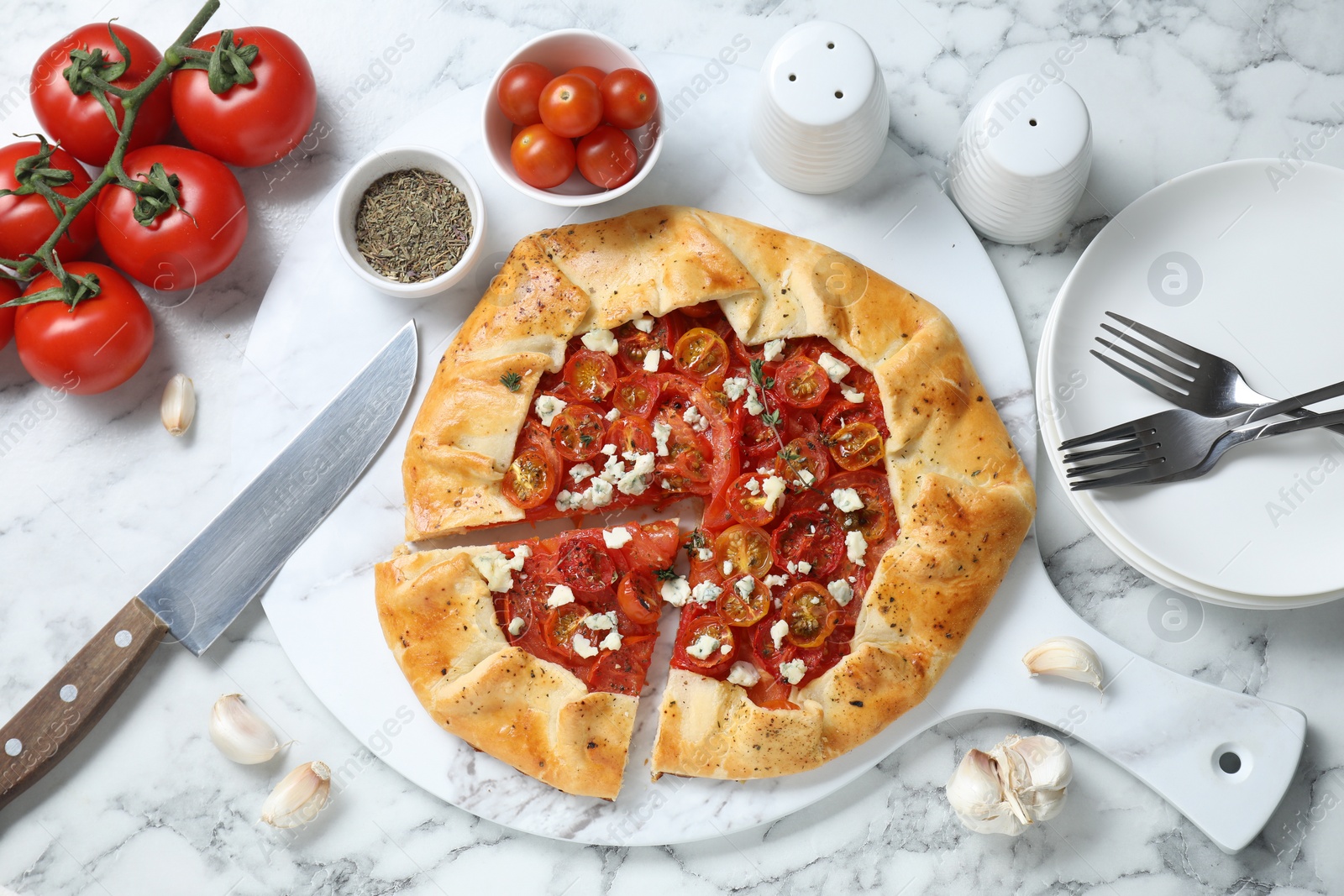 Photo of Flat lay composition of tasty galette with tomato, thyme and cheese (Caprese galette) on white marble table