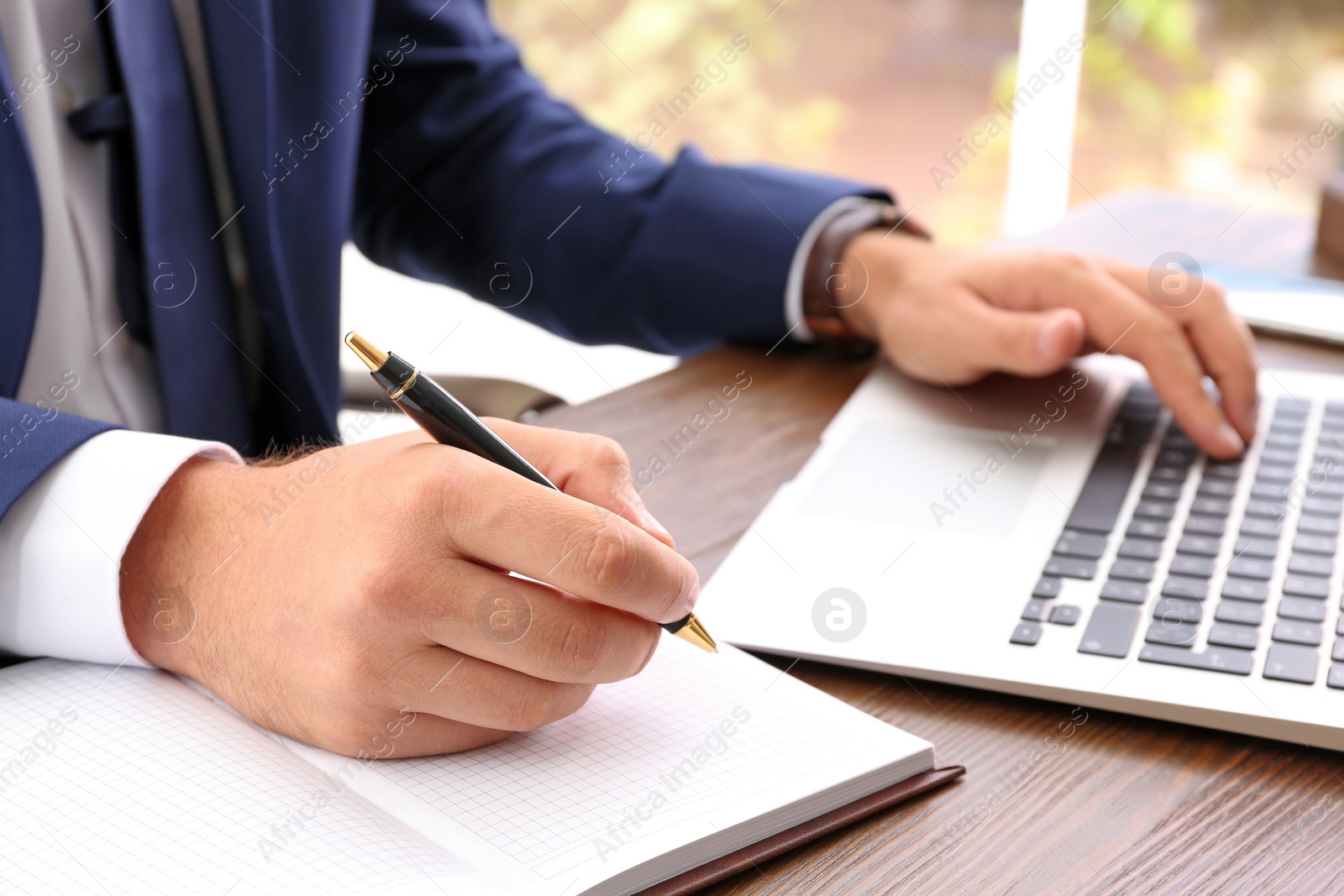 Photo of Lawyer working with laptop at table, focus on hands