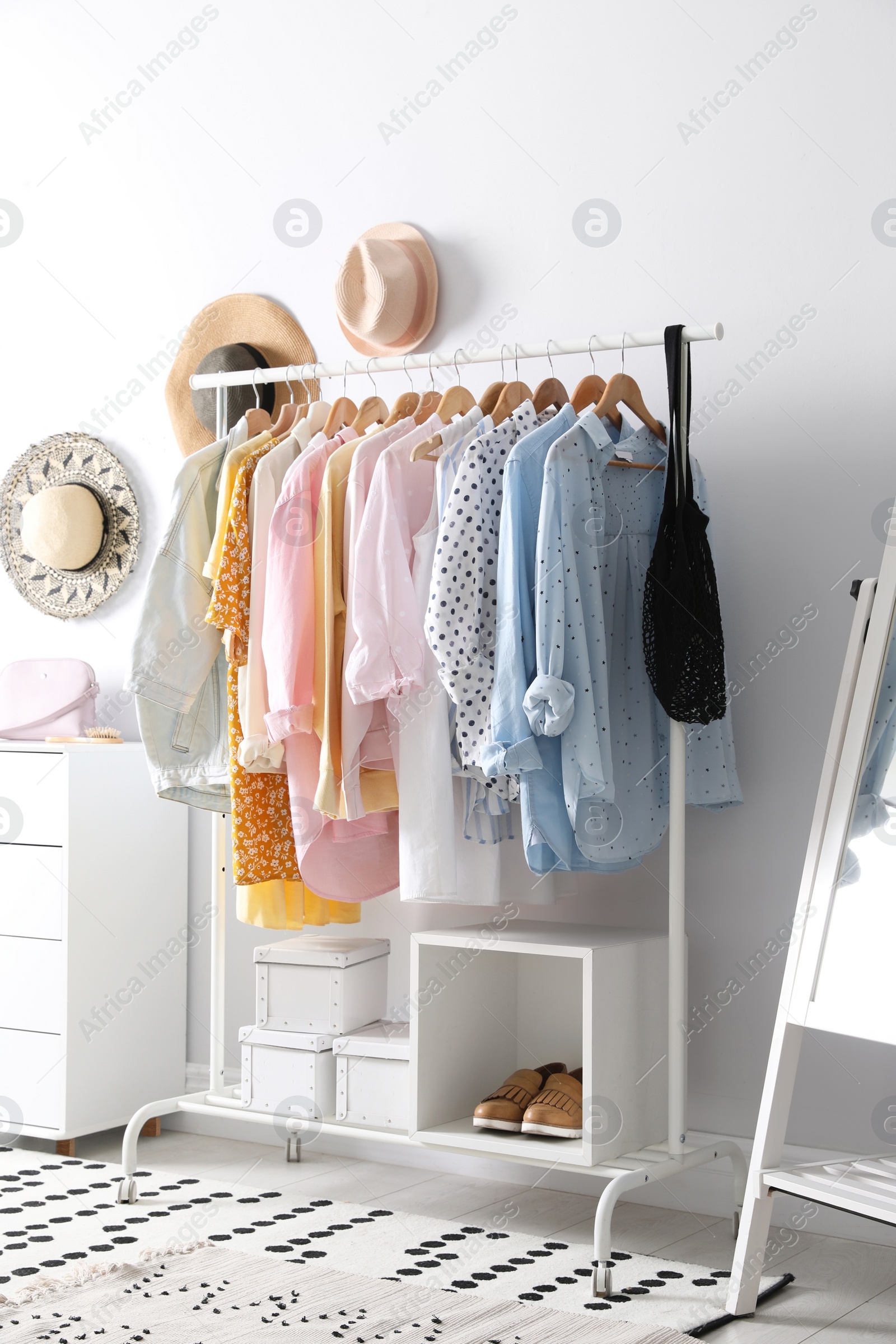 Photo of Rack with stylish women's clothes indoors. Interior design