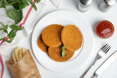 Photo of Delicious fried breaded cutlets served on white table, flat lay