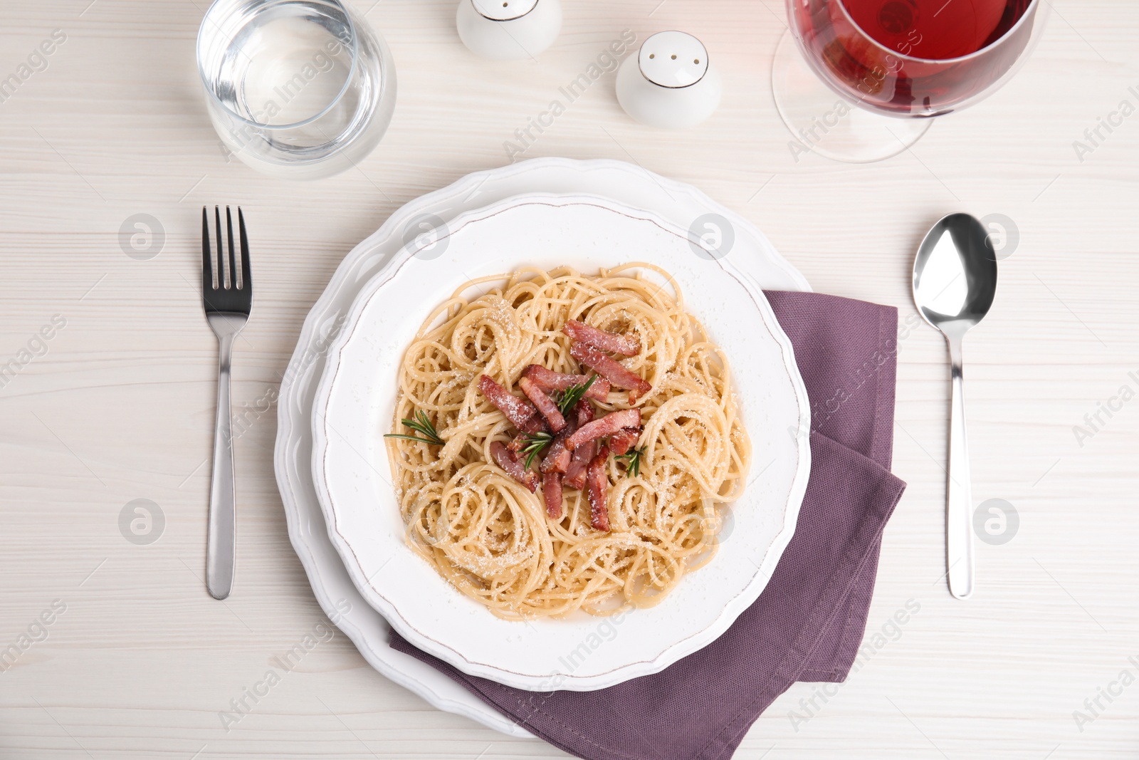 Photo of Delicious Carbonara pasta served on white wooden table, flat lay