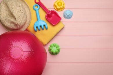 Photo of Flat lay composition with beach ball and sand toys on pink wooden background. Space for text