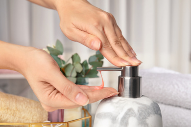 Photo of Woman using soap dispenser indoors, closeup view