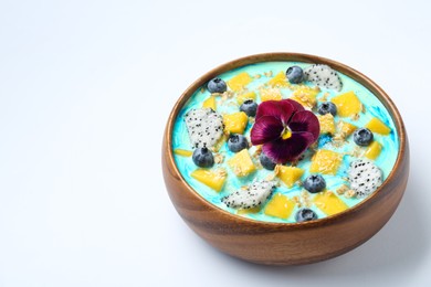 Photo of Delicious smoothie bowl with fresh fruits, blueberries, flower and oatmeal on white background, closeup. Space for text