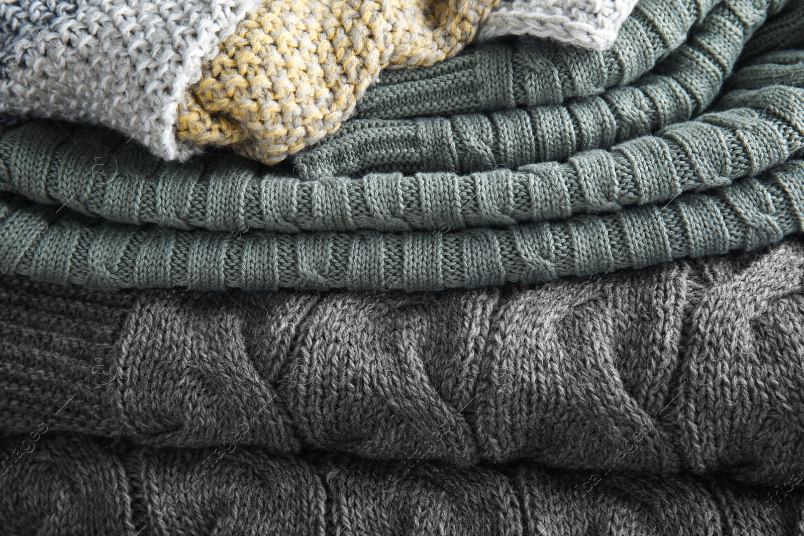 Photo of Stack of soft warm plaids as background, closeup